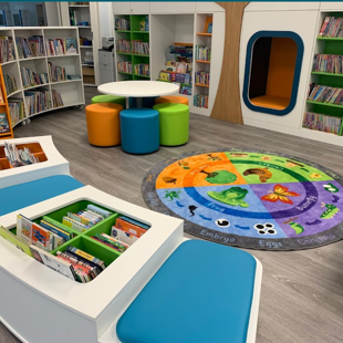 inside of a library with bright coloured chairs and bookshelves