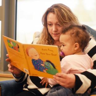parent reading toddler a book