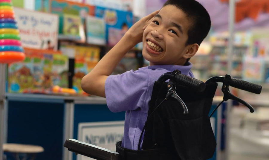 Happy child in wheelchair in a school classroom