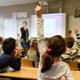Raised hands in a school classroom